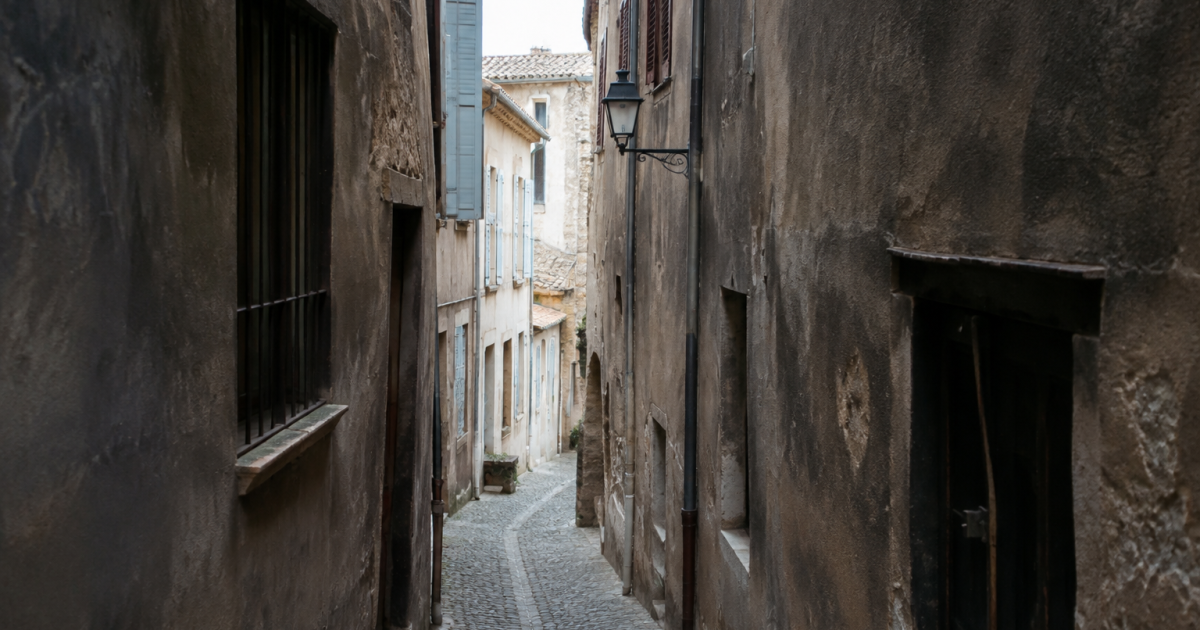 Immeubles anciens surplombent ruelle etroite aux murs fonces