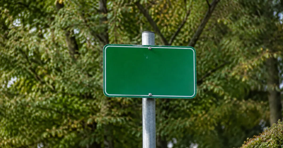 Panneau vert indiquant Sceaux fixe sur poteau devant arbres