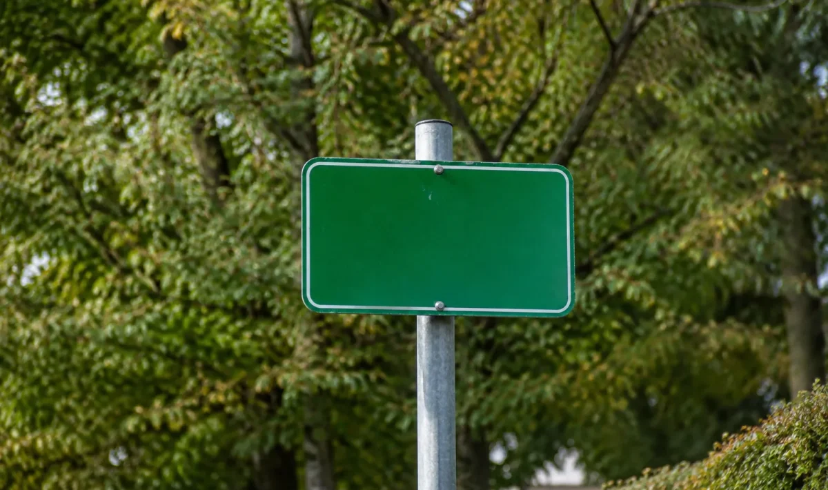 Panneau vert indiquant Sceaux fixe sur poteau devant arbres